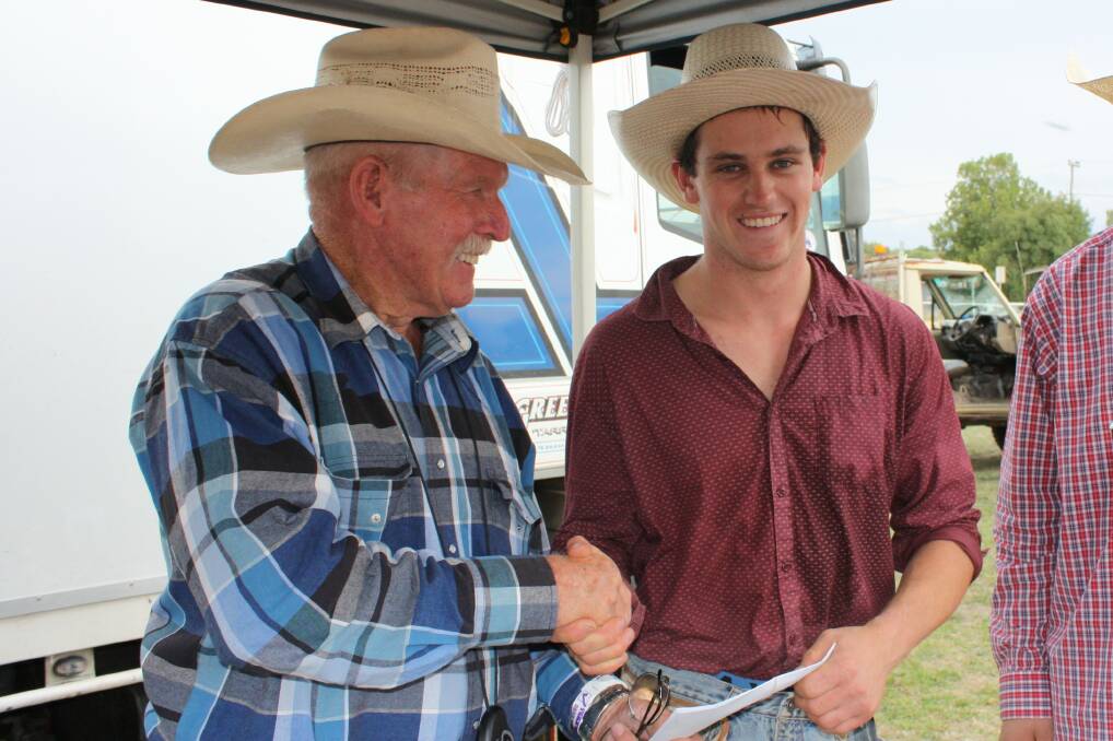 Brock Taylor receiving prize money for placing 1st in the Open Bull Ride presented by Tony Hobbs.
