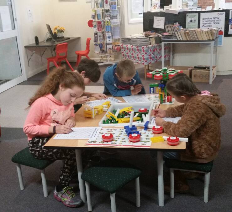 Local children enjoying the school holiday attractions at the Grenfell library. Photo E Kearnes. 