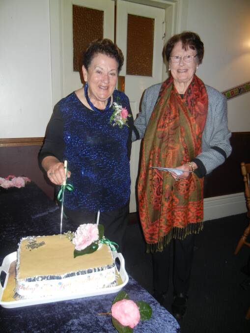 Patricia Reid cutting her 80th birthday cake with good friend Coral Mitton. 