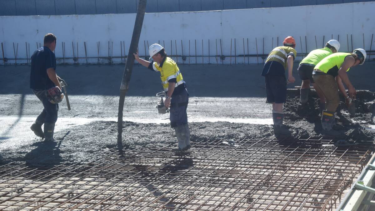 The cement is being poured for the first stage of the floor construction.

