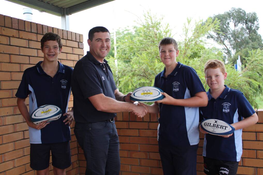 Junior Rugby Union players Tom Robinson, Harrison Starr and Oscar Schaefer accepting the donation on behalf of the club from Mr Neil Stainthorp of Graincorp. 
