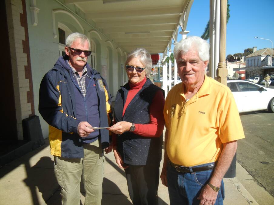 Maureen Gault receiving her Lions Mini Lotto win of $10,000 from president Chris Moran (left) and secretary Terry Carroll. 