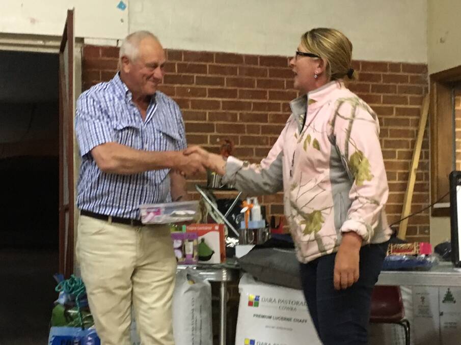Gina Glover (Team Paint Girls) presents Don Robinson (President of the WMM committee) with the money they raised for Grenfell Can-Assist. 