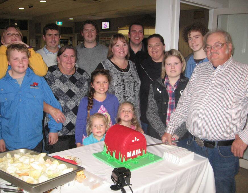 Peter, cutting his retirement cake with his wife Liz and all of their children and grandchildren. 