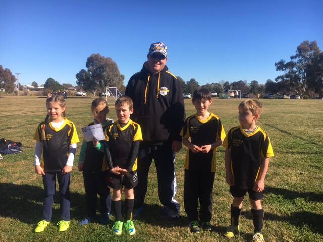 The Grenfell Junior Soccer U7s Honey Bees are Maddison, Adelaide, Charlie, William and George with coach Brendan. Photo H Troth.