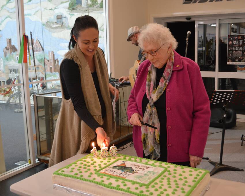 Festival Patron Kathleen Smith with Tourism officer Claire McCann lighting Henry's birthday cake candles.