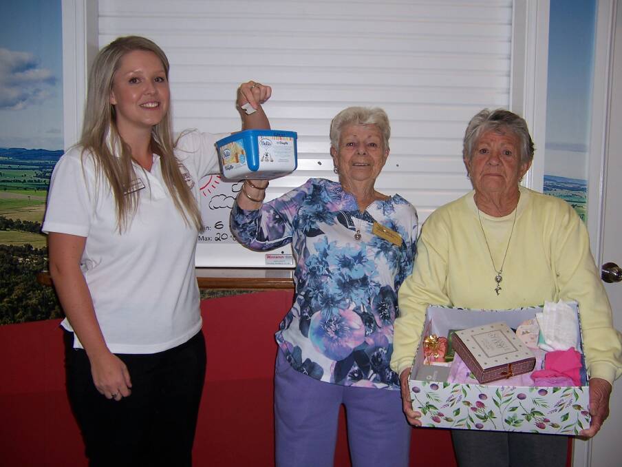 Casey Bowerman draws the winner of the Mother's Day Raffle with Margaret Whitty and Elaine Keys.