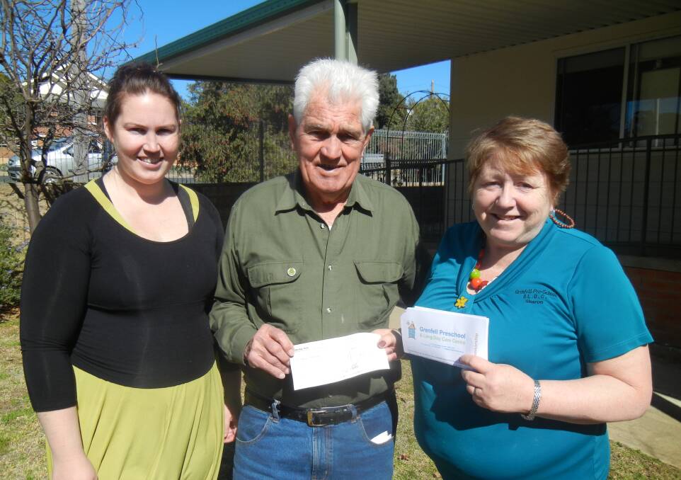 Lion Terry Carroll presenting a cheque for $500 to Sharon Grant (R) and Melissa Martens for sponsorship at the Grenfell Preschool and Long Day Care Centre.