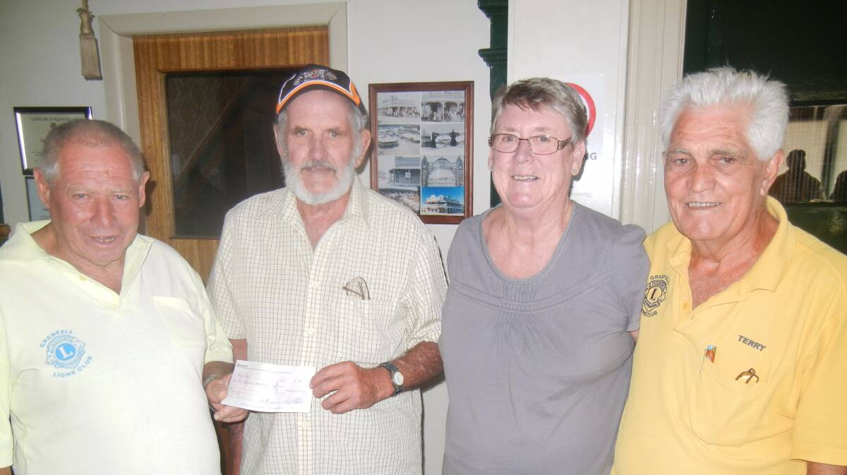 Lions Treasurer Allan Stokes assisted by Secretary Terry Carroll presenting Doug Reid and his wife Vicki with the prize winning cheque for $10000.


