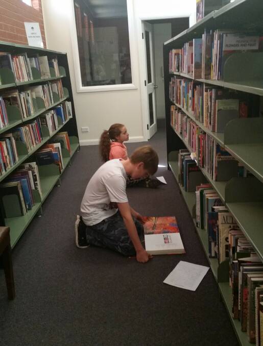 Searching for clues during the school holiday scavenger hunt at the Grenfell Library. Photo E Kearnes.