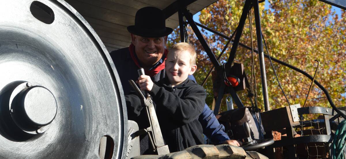 Bryton Johnson and Gary Barker driving the antique steam roller at the Henry Lawson Festival.