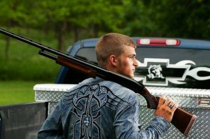 SCHOOL PORTRAIT: Dustin Langenberg of Bertrand, Nebraska, poses with a gun and a truck. Photo: Brian Baer Photography