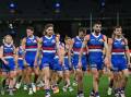 Disappointed Western Bulldogs players trudge off the field after last year's loss to West Coast. (James Ross/AAP PHOTOS)