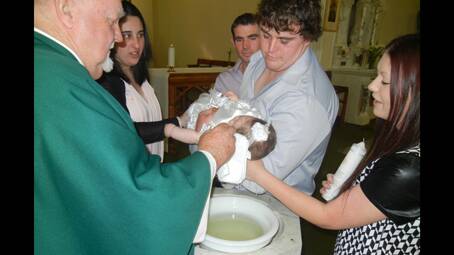 Father Tom Thornton baptising Leila Lee Ainsworth daughter of Jessica Pace and William Ainsworth during mass at St Joseph’s on Sunday morning. Godparents are Sally Dickson and Dean Friend.