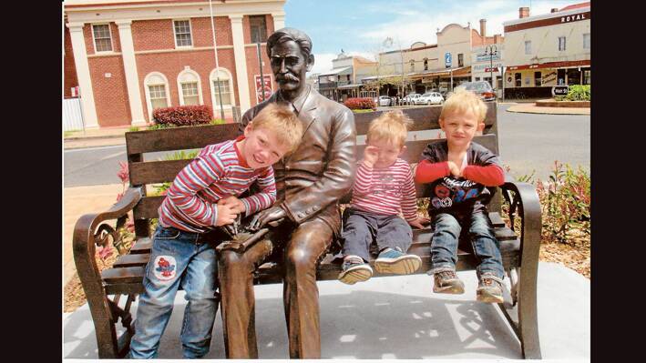 (L-R) Charlie,Harry and Thomas Walmsley who were visiting their grandparents Lorette and Phillip Walmsley on the farm had their photo take with Henry Lawson on a visit to town.(Photo contributed) 