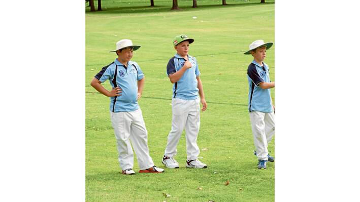 Grenfell Junior Cricketers in Cowra last Saturday, February 14. Pictured here are team mates Caleb Haddin, Ky O'Byrne and Hugh Wilson warming up to take the field. 