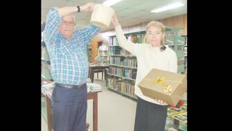 MOTHER’S DAY RAFFLE: Library committee member John Skelton (l), with Librarian Anne Gault, drawing the winning ticket for the Friends of the Grenfell Library (FOGL’s) Mother’s Day raffle at the Library. 