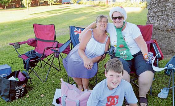 Looking the part and enjoying the great music and weather at the Carols on Saturday evening were (l/) Lyn Hucker, Deb Wilson and Jarrad Wilson.
