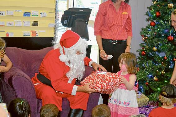 Stella Fanning receives a gift from Santa at the Bowling Club Kids Christmas Party.