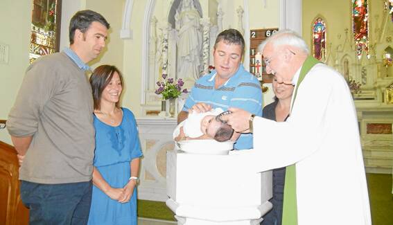 Maisie Jane Baker receiving the Sacrament of Baptism on Sunday October 27. Father Allen Crowe officiated at the service. Pictured(L-R) with Maisie are her Godparents Edward and Vanessa Dunstan from Canberra, her parents Dean and Phoebe Baker and Father Allen Crowe.