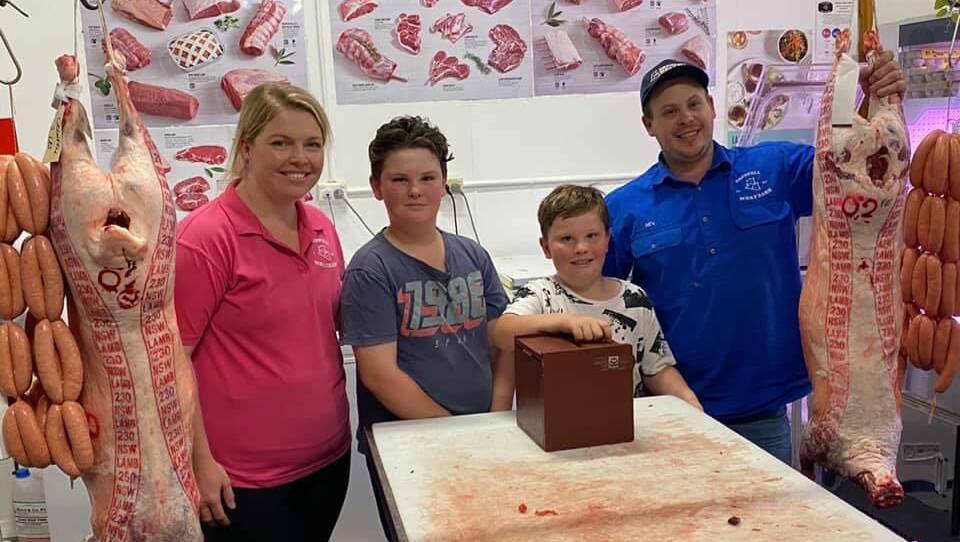 Lachlan and Hayden Rolls drawing the winning ticket with sponsors Nev and Emily Essex from Grenfell Meat Barn.