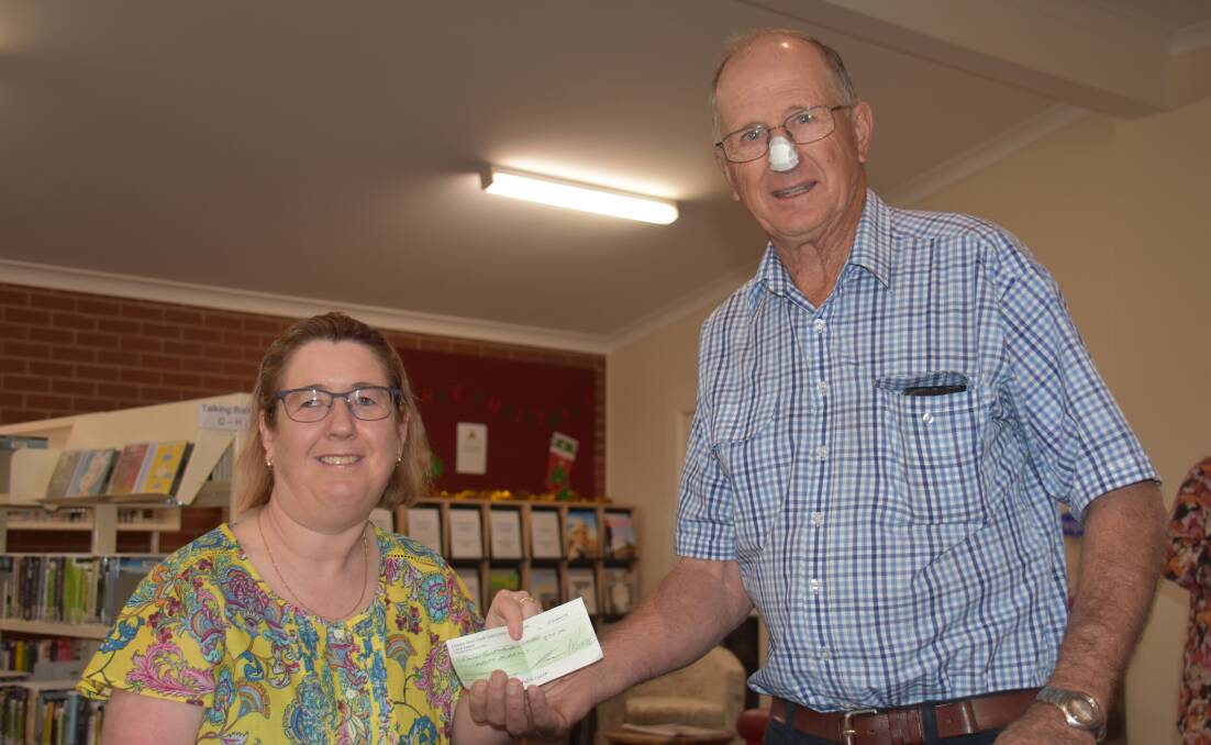 Jasmine Pipe, president of the Friends of Grenfell Library committee presents a cheque donation to Peter Spedding, president of the Grenfell branch of the Country Education Foundation. 