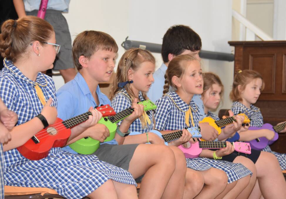 Students playing the ukulele during their end of year concert performance. 
