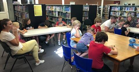 Children and parents enjoying the school holiday bingo at the library, photo supplied.