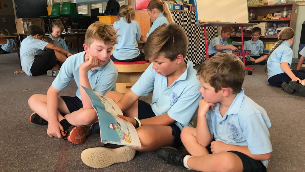 Stage 3 buddies Zack Brenner and Hugh Allen reading with their kindergarten buddy. The buddy system gives kindergarten students a big kid they recognise in the playground. 
