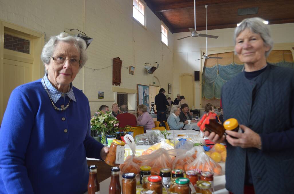 Sampling the wares at the Anglican fete are Enid Johnson and Pip Wood.