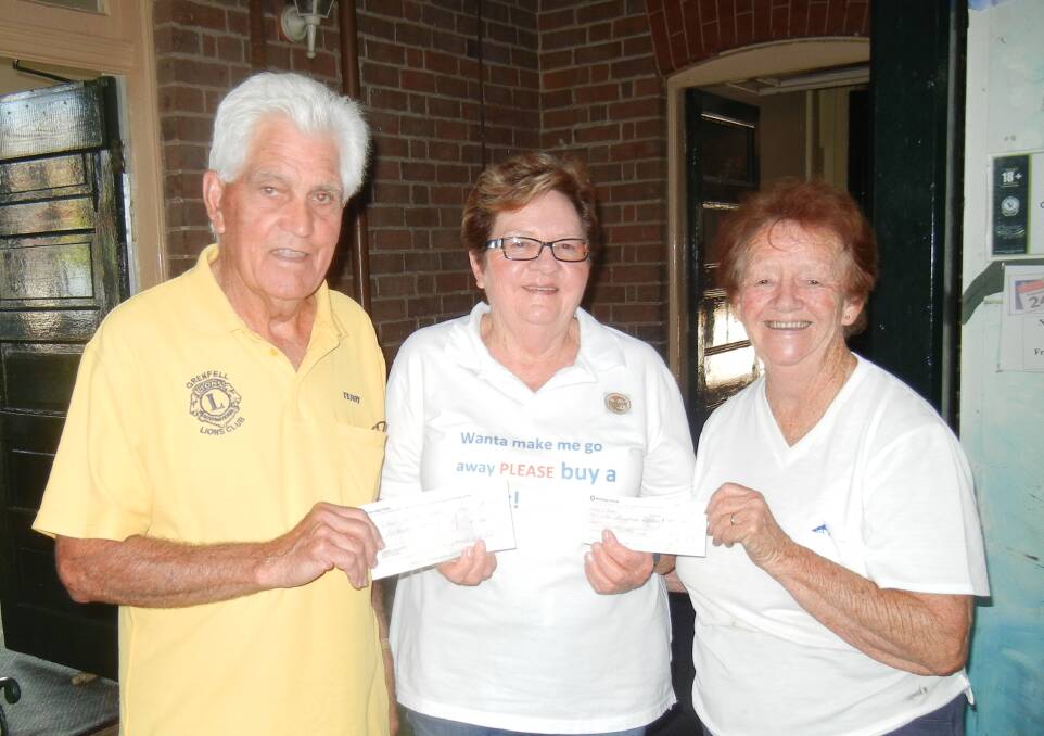 Terry Carroll (Lions) and Deidre Carroll (CWA) present cheques to Lorraine Ivins' 'Cows for Cambodia' fundraising. 