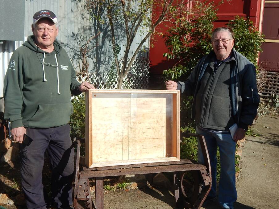 Shed members John White (L) and Joe Borg with a recently completed cabinet project for a local business. 