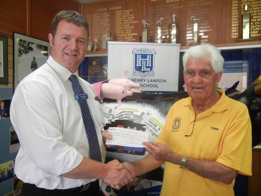 Lion Terry Carroll presenting THLHS Principal Ian Pattingale with a cheque for Presentation Day Awards. 