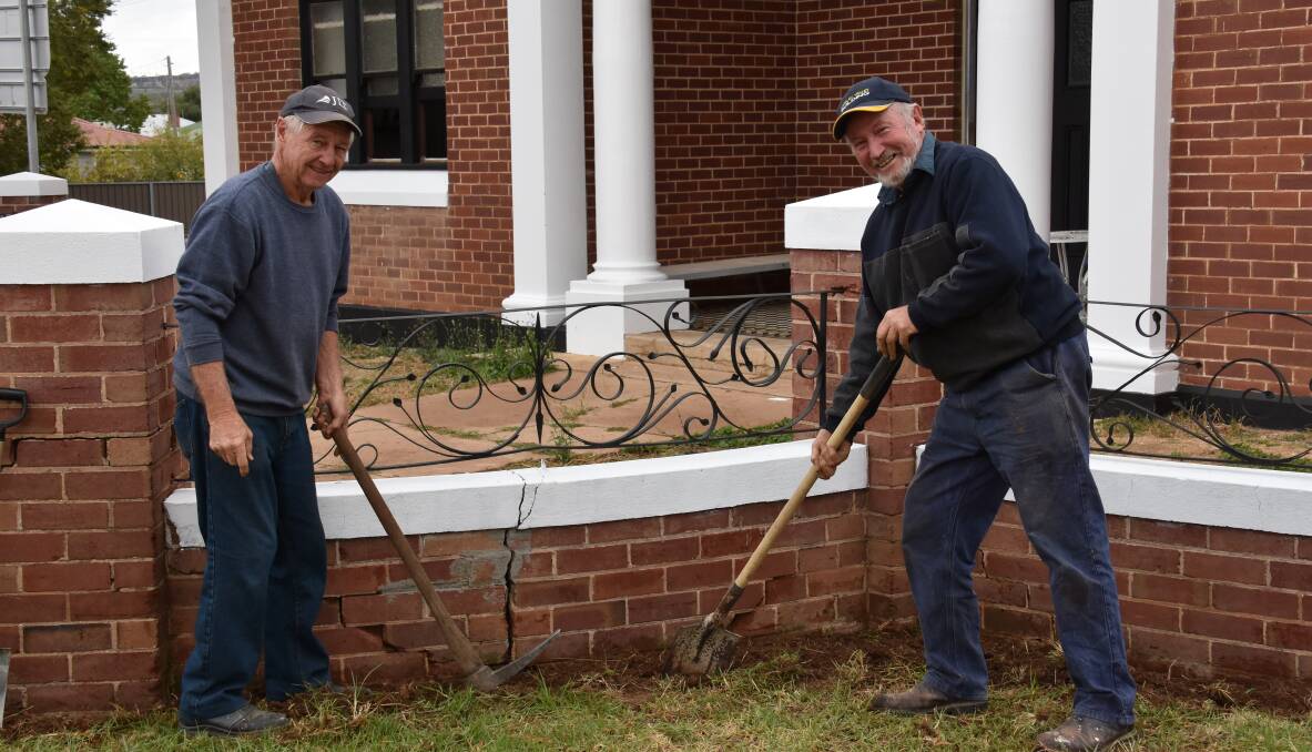 Trevor Lobb and John Hetherington prepare the soil around the old masonic lodge to plant poppy seeds.
