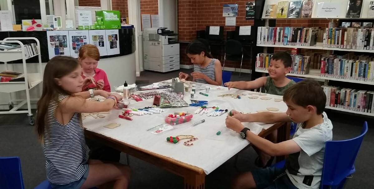 Children creating with Christmas Craft at the Grenfell Library. Image supplied