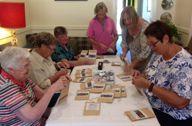  Grenfell Garden Club members preparing poppy seed packets. 