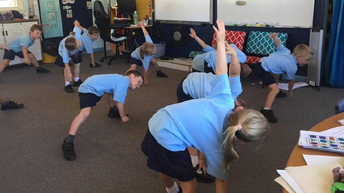 Kindergarten students enjoying some relaxing yoga. 