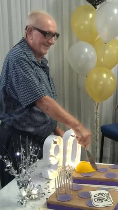 George cutting his 90th birthday cake. 