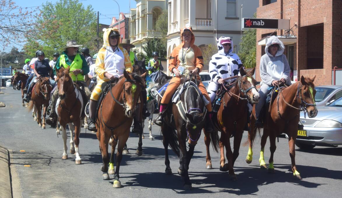 A huge group of over 100 riders join in the 'Wacky Wednesday' ride through Main Street during the 2017 Weddin Mountain Muster.