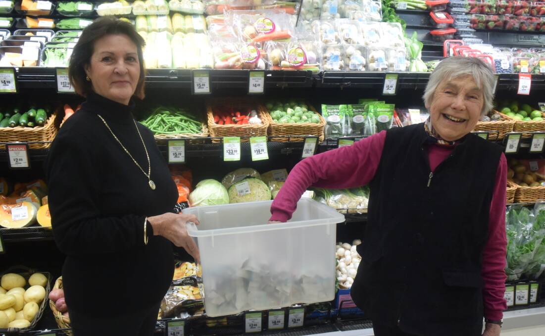 Roma Sinclair (R) draws the winning ticket in the recent Grenfell Junior Eels Cricket Club raffle and is pictured here with Gail Smith holding the tub.