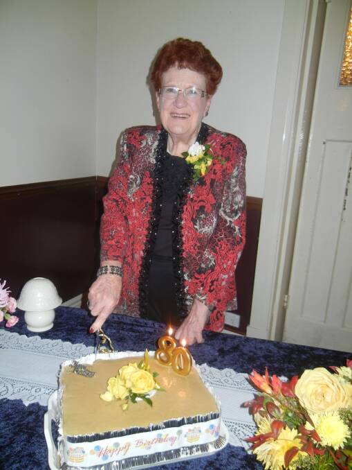 Robyn Logan cutting her 80th birthday cake. 
