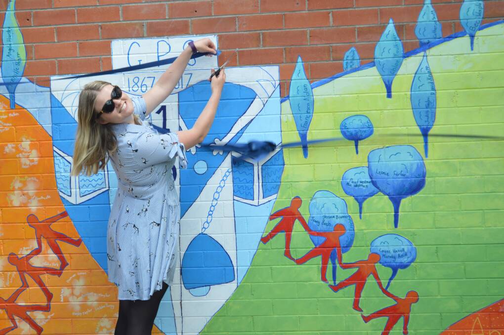 SESQUICENTENARY CELEBRATIONS: Grenfell Public School teacher and mural designer Francesca Nolan cuts the official time capsule internment ribbon.