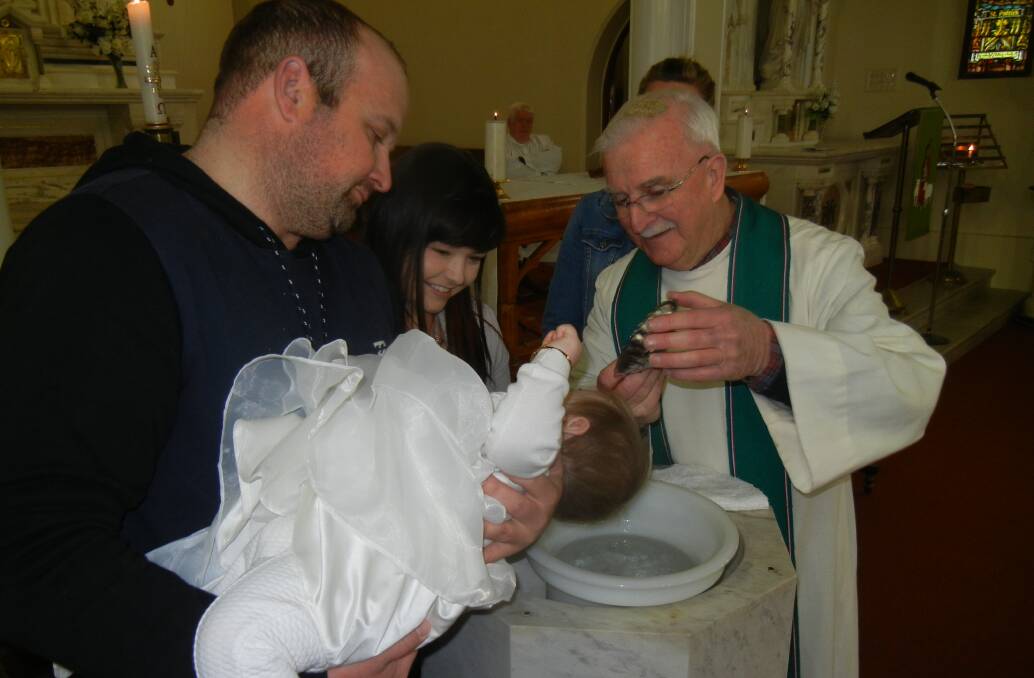 Amarlie Rose Hewen with her parents Brendan and Krystle being baptised by Fr Allen Crowe. 
