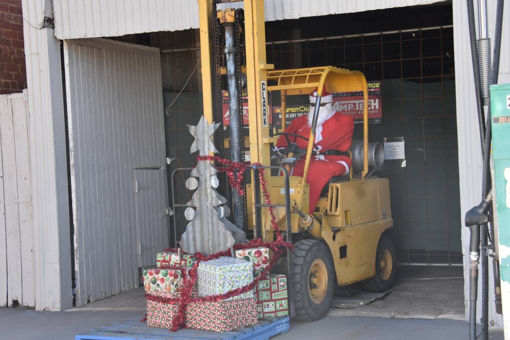 Santa delivering presents on a forklift. 