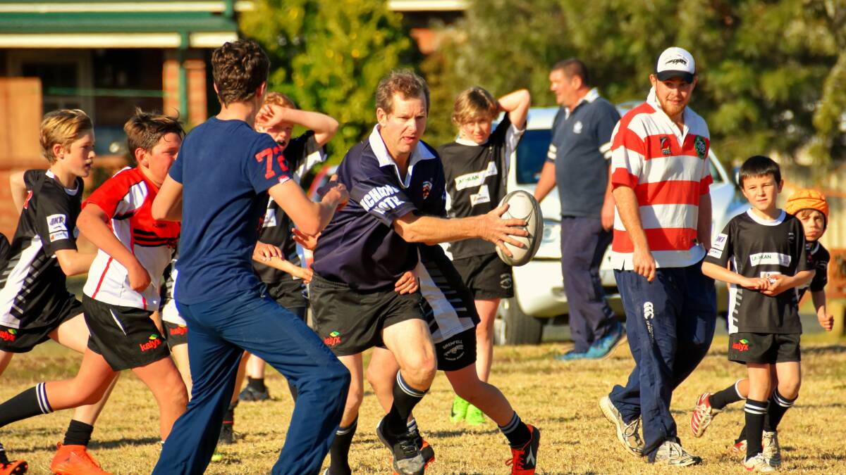 Paul Taylor offloads during the Kids v Dads game at RB Bembrick field. 