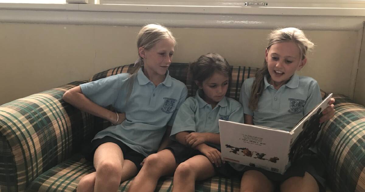 Stage 3 buddies, Nakarla Hardy and Arabella Wood reading with kindy student Claire Brenner.  