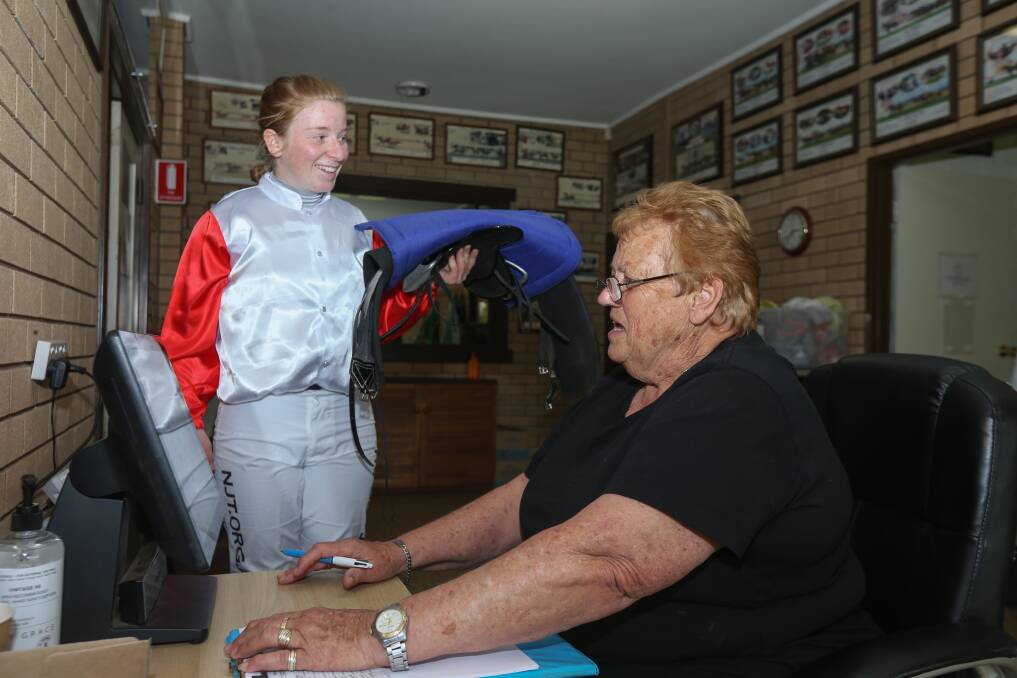 On the job: Dot Fox checks the weight of apprentice jockey Ellen Hennessy after race three at Albury on Thursday. The clerk of scales from Wangaratta has stayed on the border for three months to keep her part-time job because of restrictions. Picture: TARA TREWHELLA