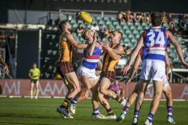 Western Bulldogs midfielder Adam Treloar gets crunched by Hawthorn players Conor Nash and James Worpel during a pre-season clash at UTAS Stadium. Pictures by Craig George 